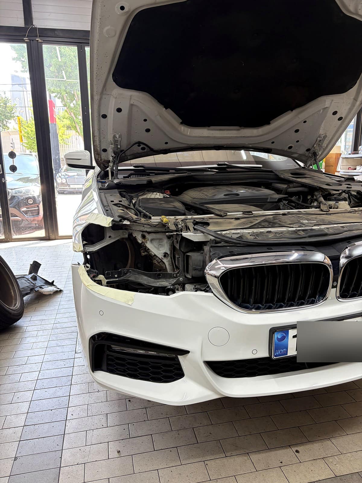 BMW 5시리즈(G30) 엔진룸을 열고 헤드라이트 상태를 점검하는 모습