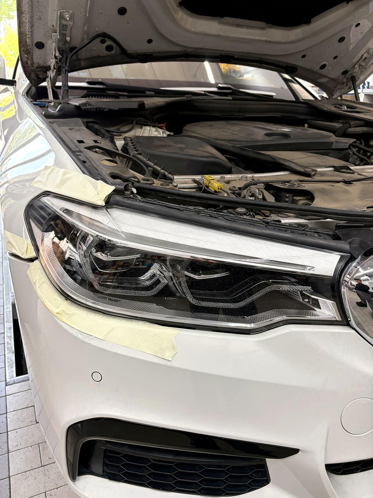 BMW 5시리즈(G30) 헤드라이트를 탈거하고 테이프로 고정해둔 모습