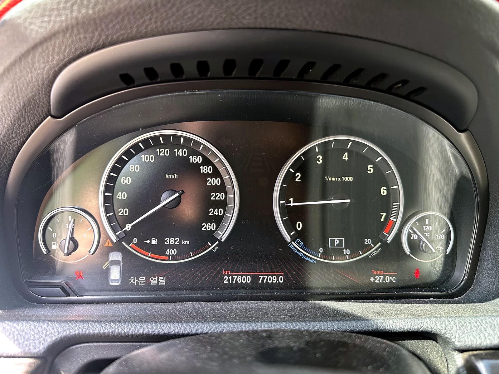 BMW 535i GT 계기판. 온도 게이지 옆에 경고등이 점등되어 있고 누적 주행거리 217,600km가 표시된 모습