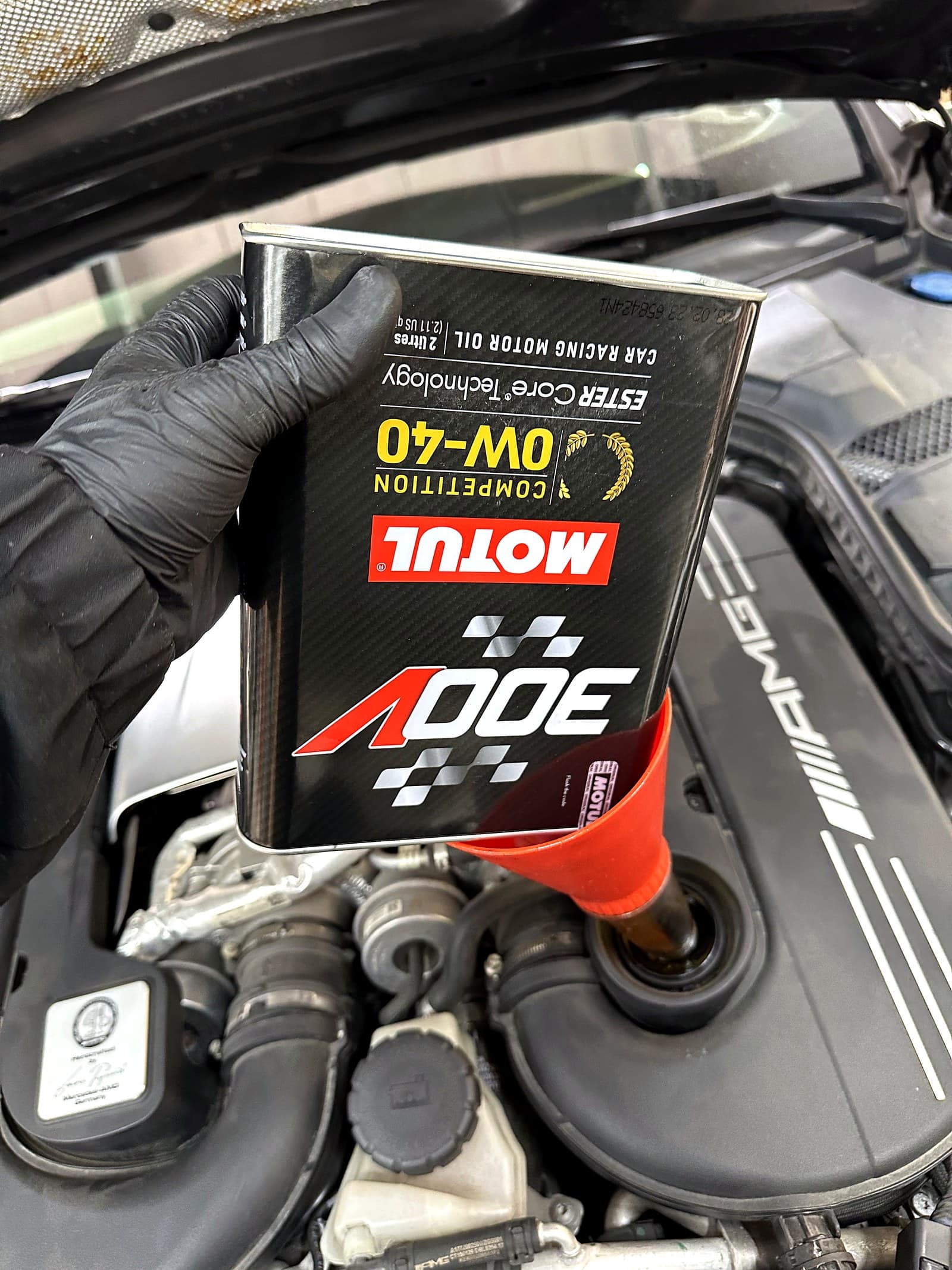 모듈 300V 컴페티션 0W-40 레이싱 엔진오일을 전용 깔때기로 AMG 엔진에 주입하는 모습