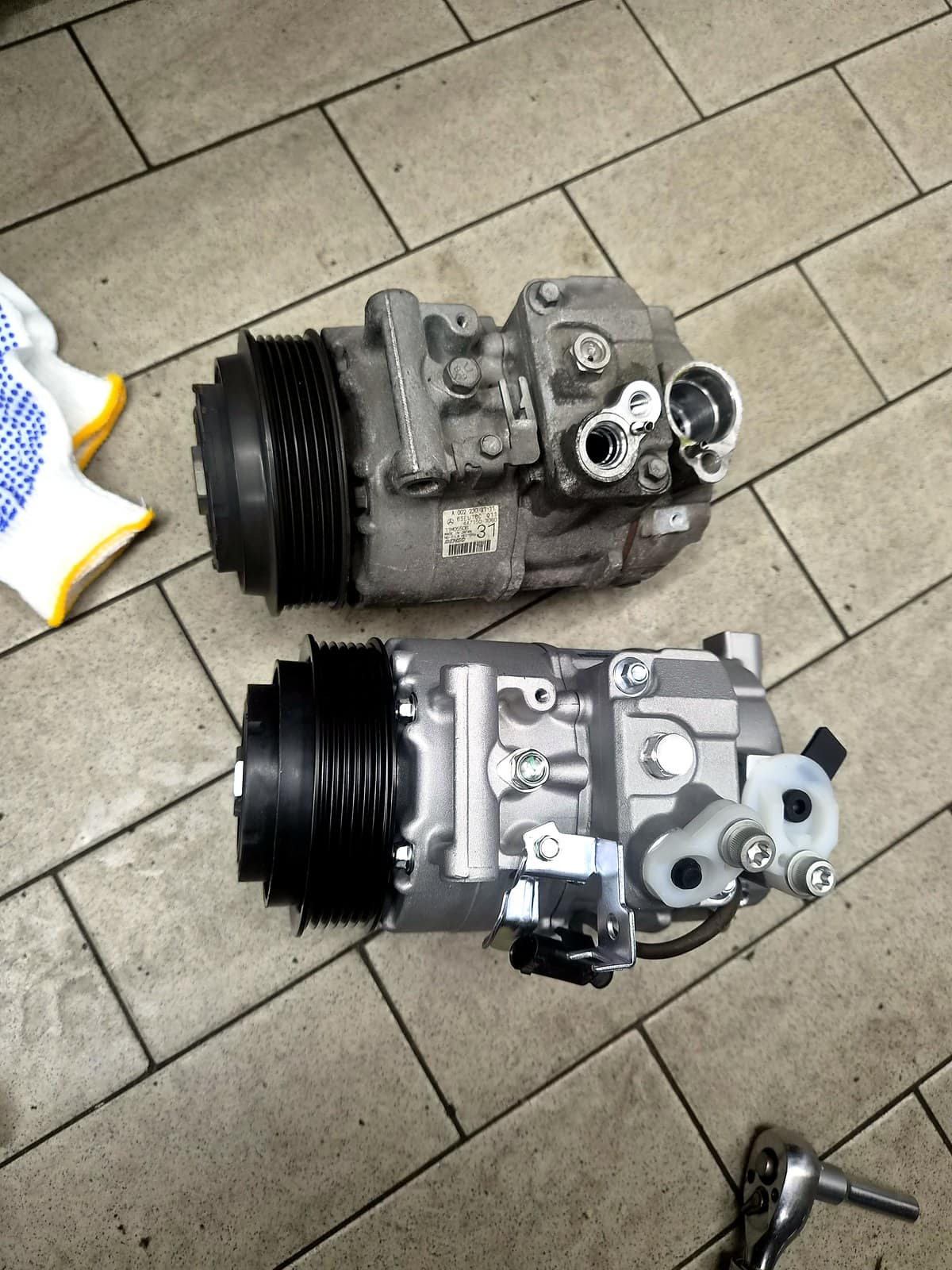 벤츠 E300(W212)에서 탈거한 기존 컴프레서와 신품 컴프레서를 나란히 비교한 모습